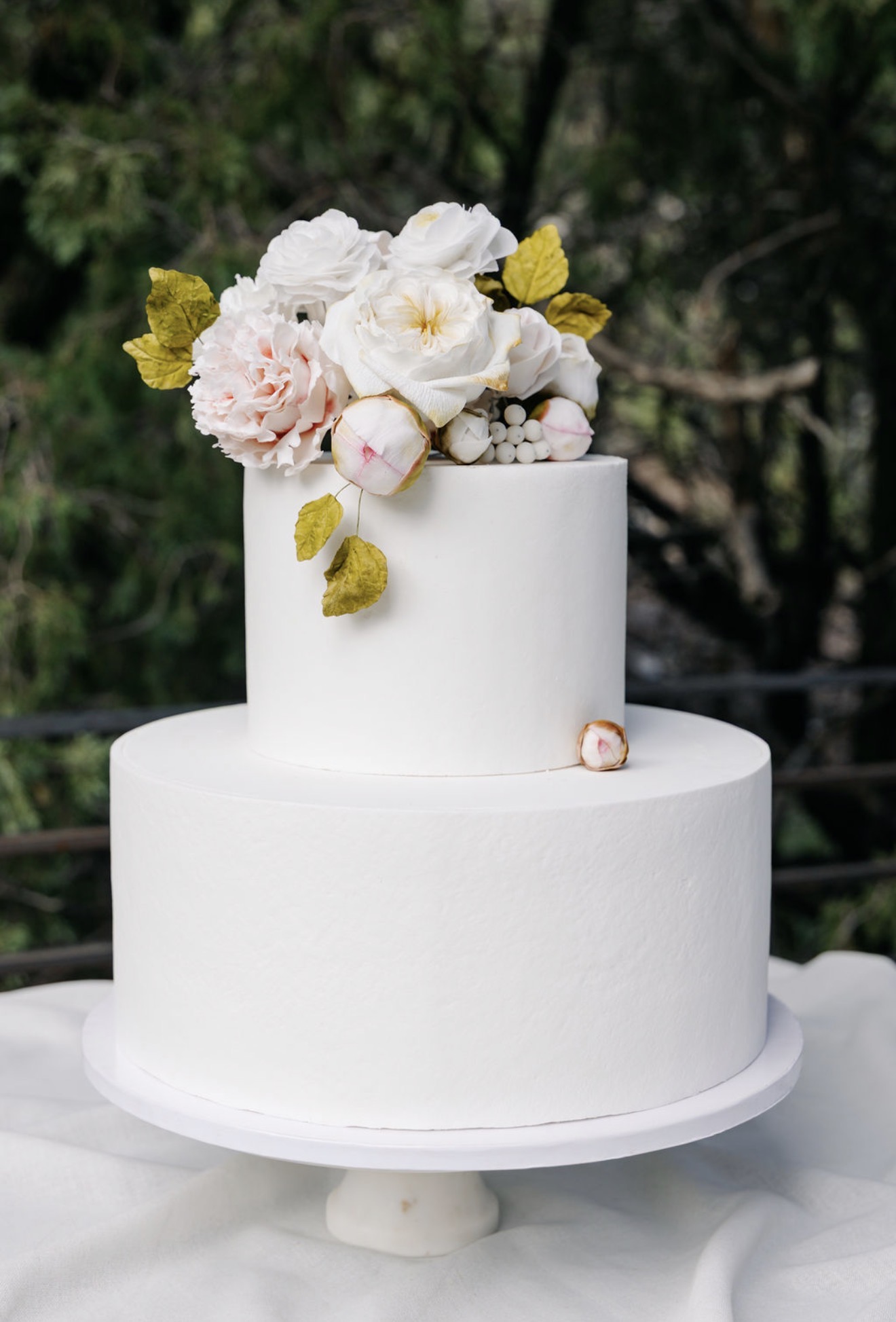 Two-tier wedding cake with sugar peonies, garden roses, and berries